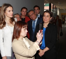 Doña Letizia acompañada por una alumna durante su recorrido por el centro, que le fue indicando, mediante una tableta, las distintas funciones que se 